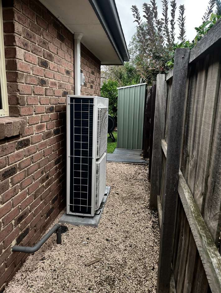 Outdoor unit installed on the side of a house with clear airflow